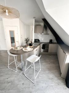 una cocina con mesa y sillas y una escalera en Charmant duplex en centre-ville, en Brive-la-Gaillarde