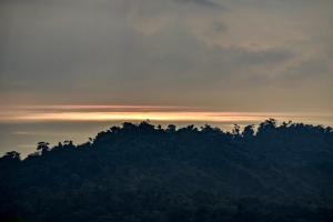 una silueta de una montaña con una puesta de sol en el fondo en Taorayiná nature lodge- immersed in the forest, en El Zaino