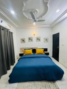 a bedroom with a large blue bed with yellow pillows at Magnifique appartement meublé 2 chambres in Lomé
