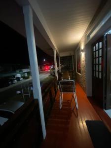 a room with a table and chairs on a porch at night at City Appartementen New Nickerie - 4-6p in Nieuw Nickerie