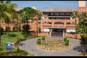 un grande edificio con un ampio giardino di fronte di Lovely family house by the golf course a Huelva