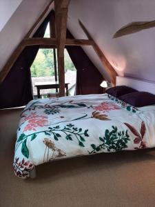 a bedroom with a bed with a floral bedspread at Gîte des châteaux de la Loire in Villandry