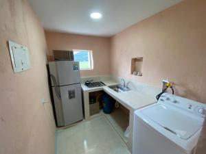 a small kitchen with a sink and a refrigerator at Casa Aurora Tibasosa Boyaca in Tibasosa