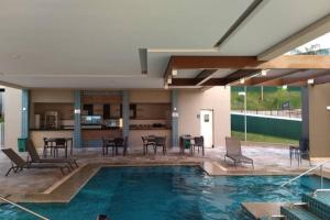 a swimming pool with chairs and a table in a house at Enjoy Solar das Águas Olímpia in Olímpia +8 photos