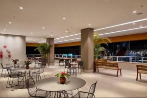 a lobby with tables and chairs and a cafeteria at Enjoy Solar das Águas Olímpia in Olímpia