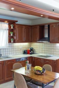 a kitchen with wooden cabinets and a table with bananas on it at Amarlia Villa in Skaleta