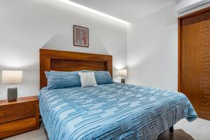 - une chambre avec un lit bleu et une tête de lit en bois dans l'établissement V Golf 601, à Puerto Vallarta