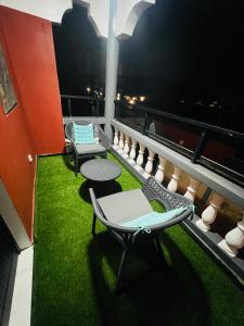 a balcony with chairs and a table and grass at Magnifique appartement meublé 2 chambres in Lomé