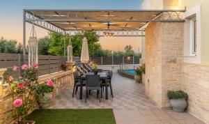 a patio with a table and chairs under a pergola at Amarlia Villa in Skaleta