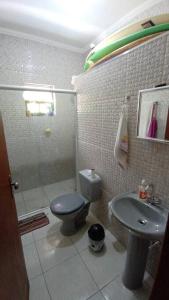 uma casa de banho com um chuveiro, um WC e um lavatório. em Casa espaçosa à 100 m do mar em Mongaguá