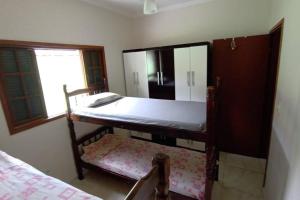 um quarto com 2 beliches e uma janela em Casa espaçosa à 100 m do mar em Mongaguá