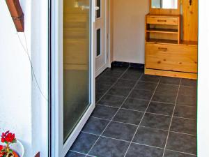 a kitchen with a tiled floor and a refrigerator at Ferienbungalow Brigitte in Spandowerhagen