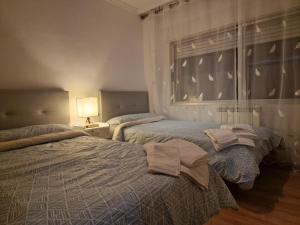 1 dormitorio con 2 camas y toallas. en Lovely Balaídos, en Vigo