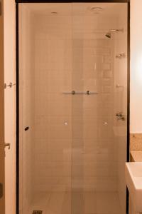 a glass shower in a bathroom with a sink at Suíte América na Pelinca in Campos dos Goytacazes