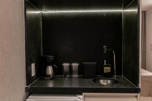 a black counter top with a sink in a kitchen at Suíte América na Pelinca in Campos dos Goytacazes