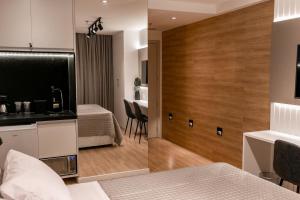 um quarto de hotel com uma cama e uma cozinha em Suíte América na Pelinca em Campos dos Goytacazes