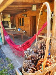 a hammock in front of a log cabin at Cabañas don graziano in Azul