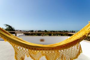 a hammock on a balcony overlooking the beach at Villa Aura, piscina privativa e rooftop com vista excepcional pro mar, 150m do mar e do Rancho do Kite, Praia do Prea in Prea