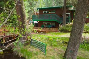 Joseph的住宿－60073 Wallowa Lake Hwy (lower unit)，树林中的房屋,前面设有长凳