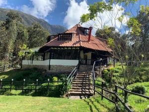 a house with a staircase leading up to it at La Roca Glamping in Arcabuco