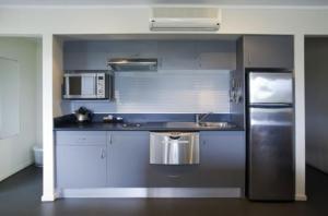 a kitchen with a refrigerator, stove, microwave and sink at Corrigans Cove in Batemans Bay