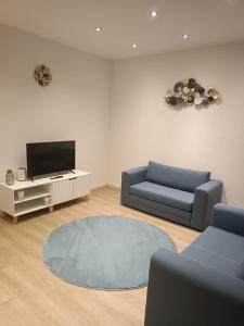 a living room with a blue couch and a tv at L8 Street - Gneisenaustraße 9 in Pforzheim