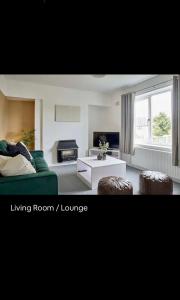 sala de estar con sofá verde y salón en Spacious 3 bedroom house in nottingham, en Nottingham