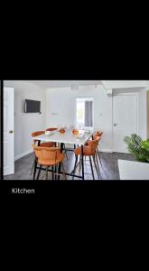 une salle à manger avec une table et des chaises blanches dans l'établissement Spacious 3 bedroom house in nottingham, à Nottingham