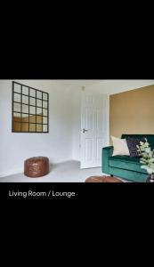 a living room with a green couch and a window at Spacious 3 bedroom house in nottingham in Nottingham