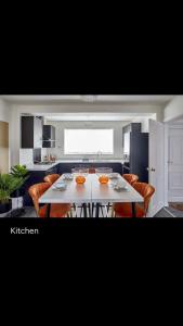 a kitchen with a white table and orange chairs at Spacious 3 bedroom house in nottingham in Nottingham