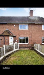 a brick house with a fence in front of it at Spacious 3 bedroom house in nottingham in Nottingham