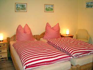 1 Schlafzimmer mit 2 Betten und rosa Kissen in der Unterkunft Ferienwohnung Haus Möwe in Freest