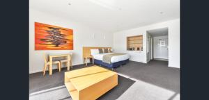 a hotel room with a bed and a desk and a table at York Cove Hotel in George Town
