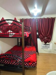 2 łóżka piętrowe w pokoju z czerwonymi zasłonami w obiekcie SEAWIND TOWER 6 CONDOMINIUM w mieście Davao