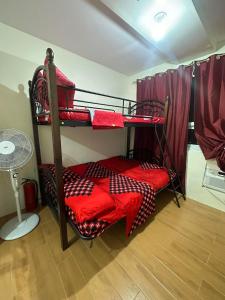 Pokój z 2 łóżkami piętrowymi z czerwoną pościelą w obiekcie SEAWIND TOWER 6 CONDOMINIUM w mieście Davao