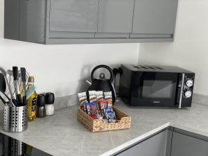 a kitchen counter with a microwave and a basket of food at Relax Inn in Bournemouth