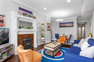 a living room with a blue couch and a fireplace at Game Day Getaway - 3BR in Vibrant Wrigleyville in Chicago