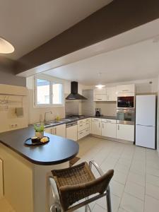 a kitchen with white cabinets and a table and chairs at Gite BA2 Epernay Centre vue sur parc in Épernay