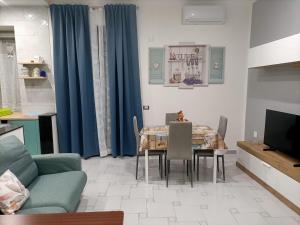 soggiorno con tavolo e tenda blu di Home 5.1 a Napoli