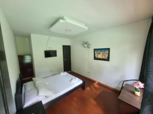 um pequeno quarto com uma cama branca em Eco Hotel La Selecta Campestre em Pereira