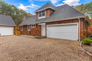 a house with two garage doors on a brick driveway at East Quogue House in East Quogue
