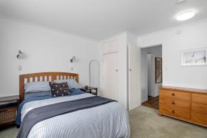 a bedroom with a bed and a wooden dresser at Maratoa - Takaka Holiday Home in Takaka