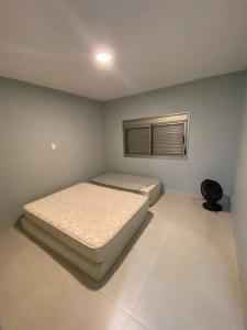 ein kleines Schlafzimmer mit einem Bett und einem Fenster in der Unterkunft Casa de campo no Santa Barbara Resort Residence in Águas de Santa Barbara