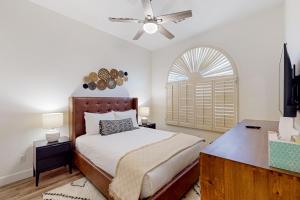a bedroom with a bed with a ceiling fan and a window at Serenity Now in Glendale +24 photos