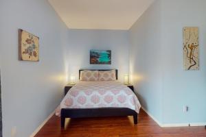 サンディエゴにあるThe Heart of the Cityのベッドルーム1室(ベッド1台付)が備わります。壁に2枚の写真が飾られています。