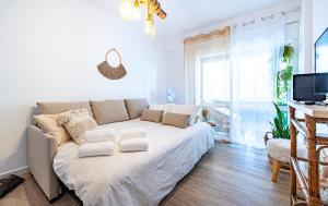 uma sala de estar branca com um sofá e uma televisão em COZY BOHO HOUSE, Elegance & Comfort in Faro Center em Faro
