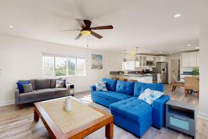 ein Wohnzimmer mit einem blauen Sofa und einem Tisch in der Unterkunft The Cliffside Bungalow in San Diego