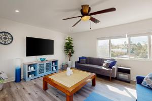 ein Wohnzimmer mit Sofa und Flachbildfernseher in der Unterkunft The Cliffside Bungalow in San Diego