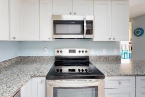 a kitchen with a stove and a microwave at Phoenix IV 4052 in Orange Beach