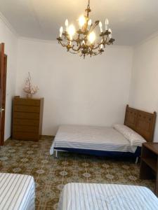 1 Schlafzimmer mit 2 Betten und einem Kronleuchter in der Unterkunft MAR i MONTAÑA en Cullera Villa Juani in Cullera